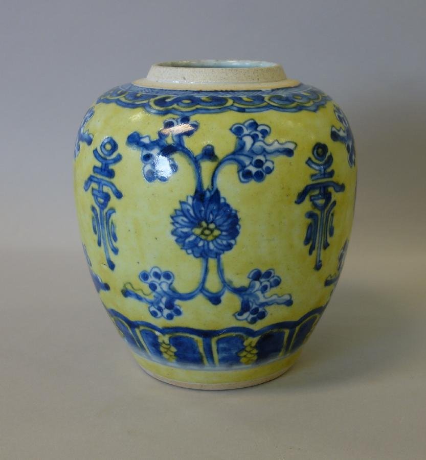 Chinese Yellow & Blue Porcelain Ginger Jar: A Chinese porcelain ginger jar. Blue and white floral decoration alternating with Chinese symbols on a yellow ground. Measures 7.5" high, 7" diameter. No lid.
