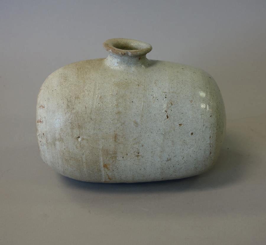 Antique Korean Bale Form Wine Flask: A Korean glazed stoneware bale-form wine flask. Late Choson / Joseon Dynasty. White glazed wine jar / flask measuring 7.5" x 5" x 5.5" high to top of opening.