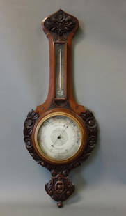 19thc English Barometer, Thomas Armstrong & Bro: An English mahogany and walnut wall barometer. The dial marked T. Armstrong & Bro., 88 & 90 Deansgate, Manchester. The case is well carved in high relief depicting sunflowers / daisies and leaves. 