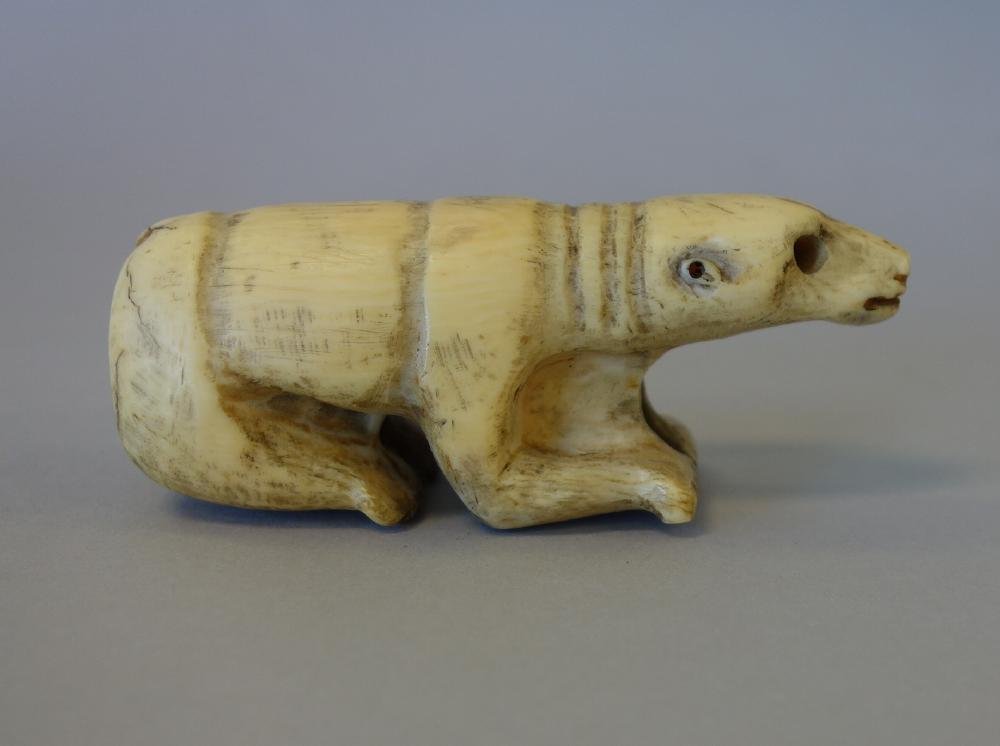 Fossilized Walrus Tusk, Polar Bear Carving: A fossilized walrus / marine ivory tusk. Antique primitive Inuit folk art carving depicting a crouching polar bear. Measures 3.75" long, 1-3/8" wide, 1.5" high. Unsigned. Search terms: Eskimo, Alaskan