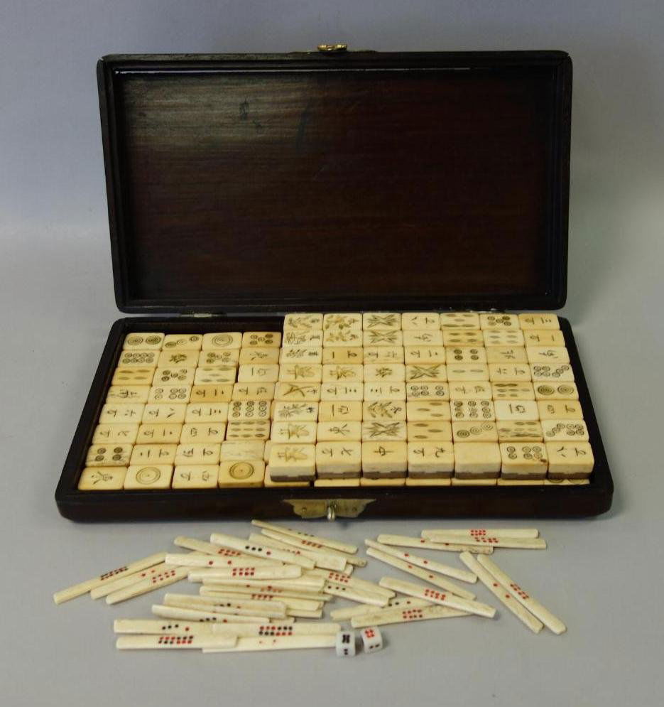 Chinese Traveling Mahjong Set in Rosewood Case: A vintage Chinese traveling mahjong set with rosewood case, early 20th century. 144 tiles plus betting sticks and two dice. The pieces are made of scrimshawed bone, dovetailed to wood backs. The dovet
