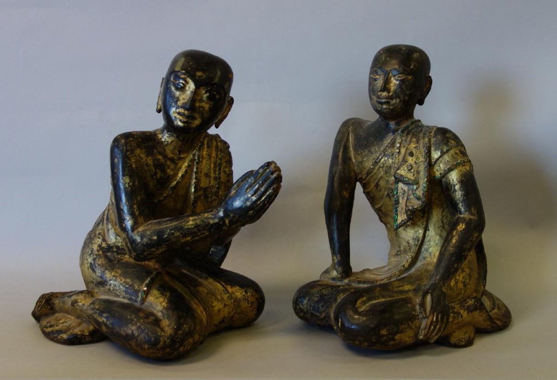 Carved & Painted Wood Buddhist Figures, Thailand: A similar pair of carved and gilt painted wood Buddhist figures. Thailand. Both kneeling and wearing robes adorned and inset with green glass and mirror stones. Each measuring approximately 14" high, 