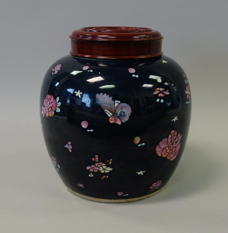 Chinese Porcelain Ginger Jar, Cobalt Ground: A Chinese porcelain ginger jar with rosewood lid, Late Qing Dynasty. Deep cobalt blue ground decorated with overglaze famille rose enamels depicting flowers and butterflies. Measures 9" high to top of