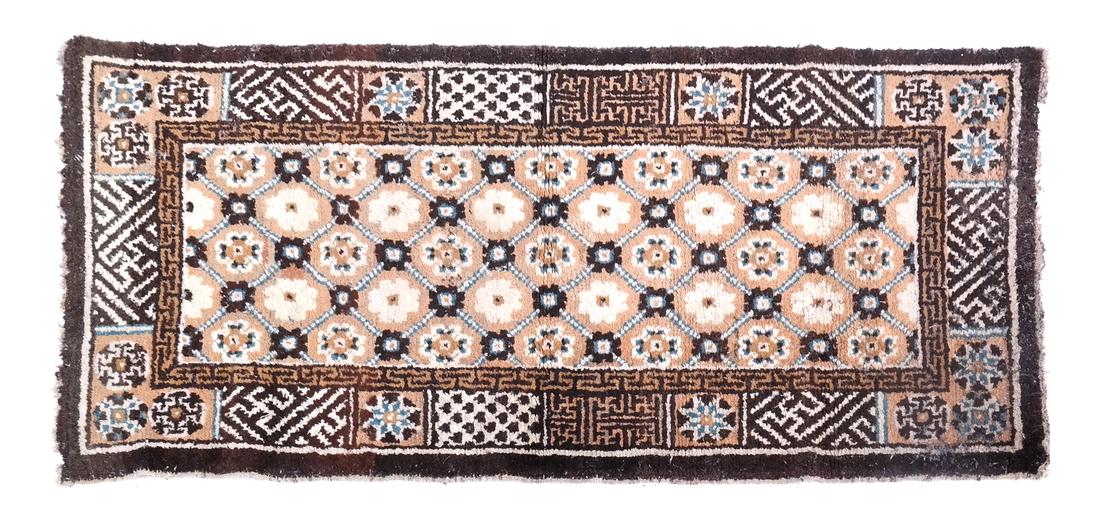 A CHINESE RUG EARLY 20TH CENTURY: The dark brown field with a rosette design 4 ft. 2 in. x 2 ft. (approximately)
