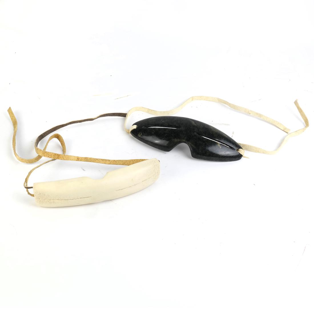 Two Pairs of Carved Inuit Sunglasses: Including a bone or a hardstone example. [5 3/4" L and 6"].