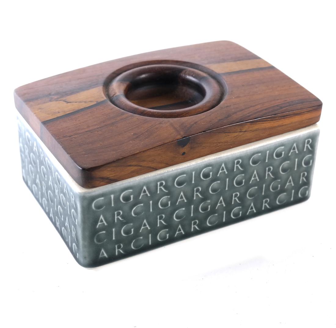 Kronjyden Cigar Humidor by Jens Quistgaard: A glazed pottery cigar box having a sculptured wood cover. Marked and signed "Kronjyden, Denmark". [4 1/4" x 6 1/4"].