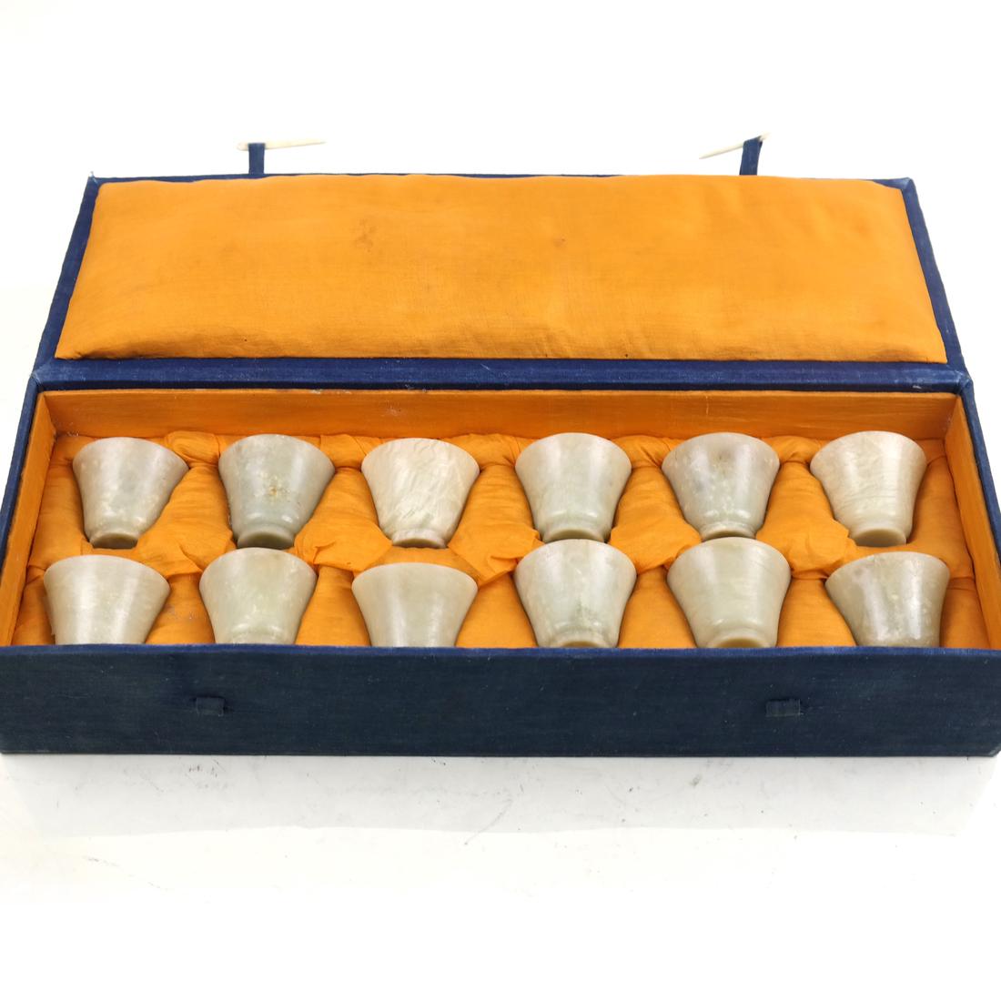Set 12 Chinese Hardstone Wine Cups: Set of Twelve Chinese Polished Hardstone Wine Cups, with fitted silk case; [Cup H: 1 5/8in; Dia: 2in; Case L: 15 3/4in]; Few natural imperfections; wear to case.