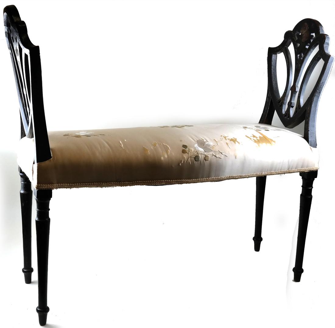 Victorian Ebonized Window Seat: 19th century, in Neoclassical-style, two ebonized shield-form arms, painted with foliage, with the shaped rectangular seat with silk upholstery. [32 1/2" H x 37 1/4" L x 15" D]. Stains to upholstery, 