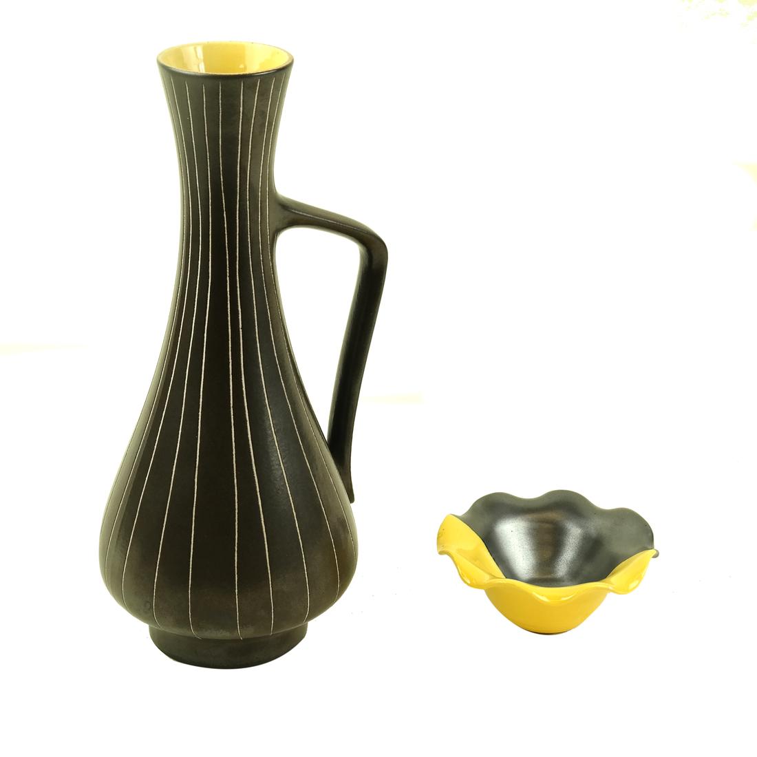 Italian Mid-Century Modern Ewer & Nut Dish: Brown glaze ever with vertical sgraffito lines and yellow interior. [6 1/4" W x 5 1/4" D x 11 1/2" H]. Accompanied by a two-tone flori-form nut dish. [4 3/8" x 2" H].