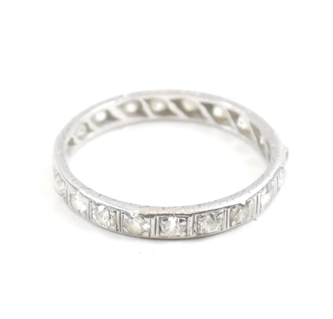 Platinum and Diamond Wedding Band: Platinum ring bearing approximately 20 small rose-cut diamonds. Total weight 1.7 dwt. Dimensions: 0.82" ⌀ x 0.11" D; 