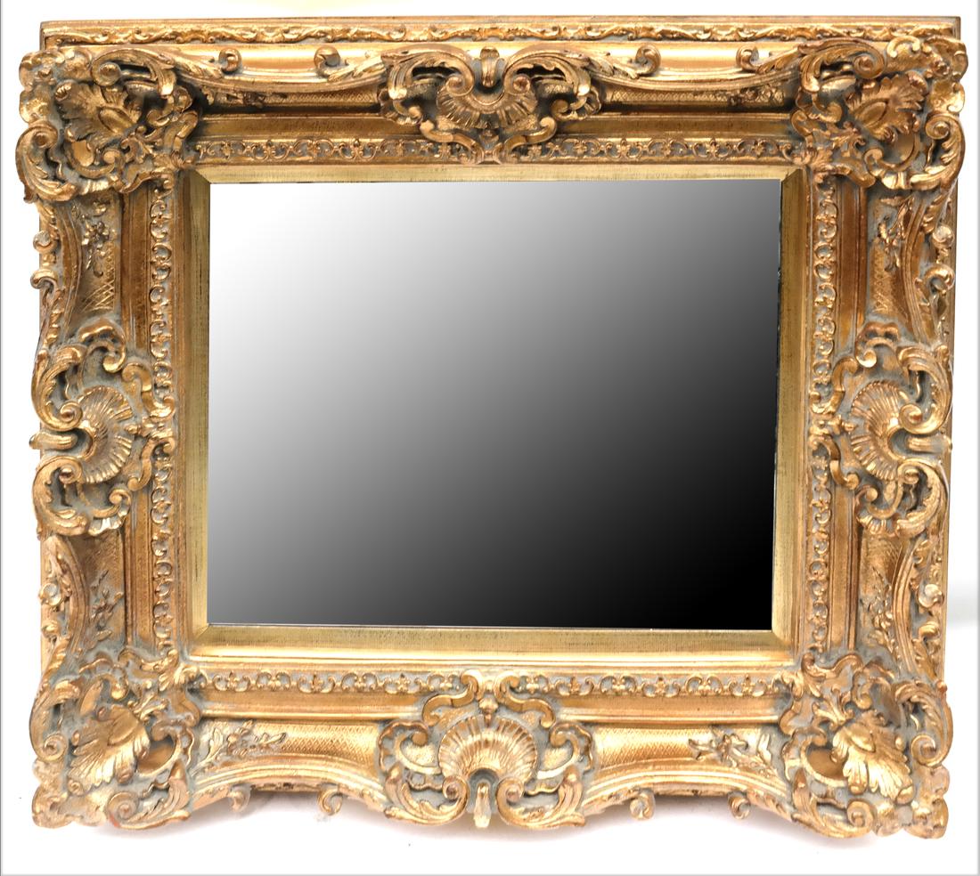 Ornate Louis XV-Style Mirror: Carved gilt wood and gesso mirror with seashell, leafy C-scroll, and diaper pattern ornament. Dimensions: 33.5" H x 37" W; 