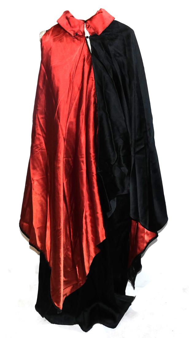 Two-Part Black & Red Dress and Over Cape Mantle: Two-piece black and red dress with over cape mantle. Polyester. 1970s. Dimensions: Base of neck to pointed hem - 50" L ; 