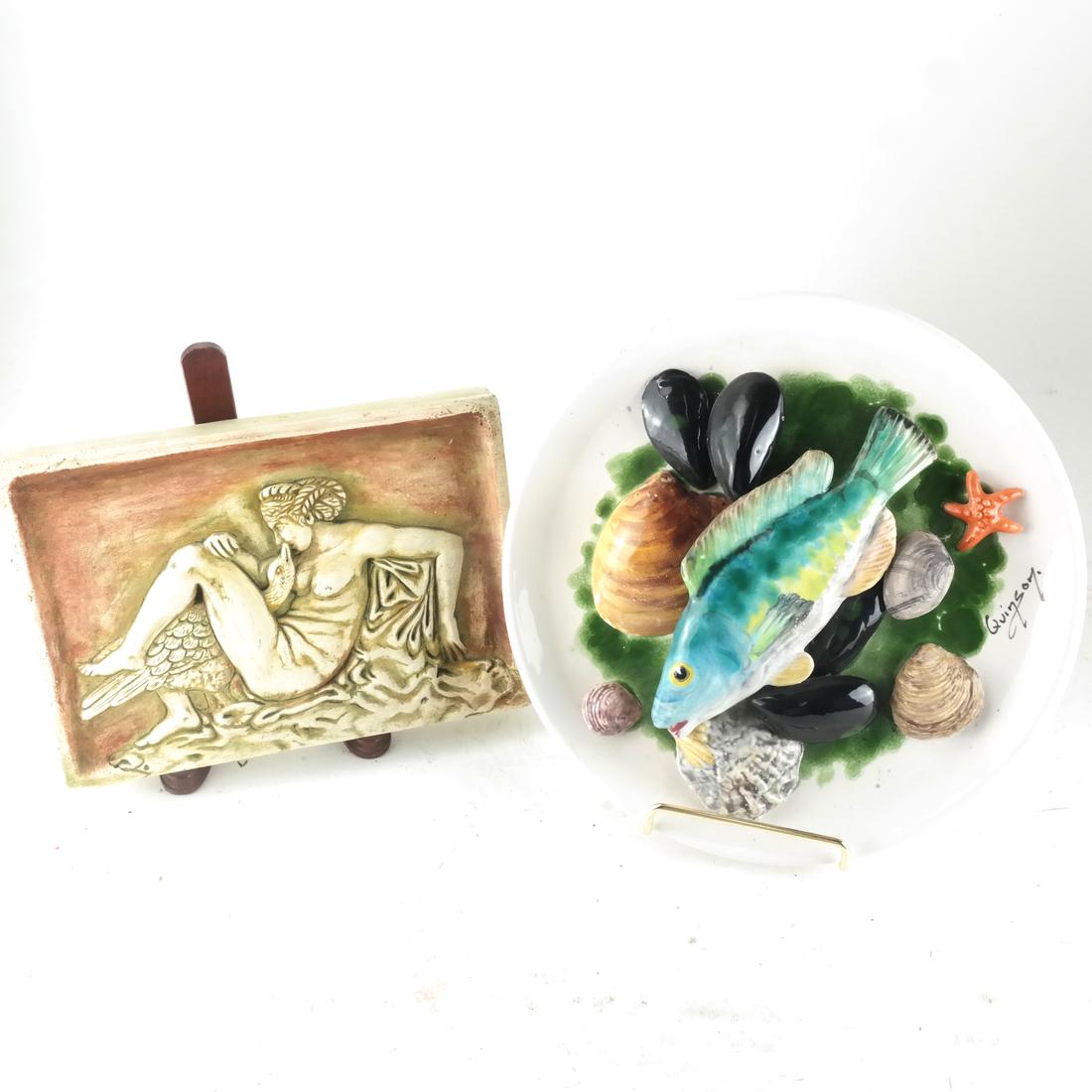 Two Reliefs: Nude and Fish: Comprises a ceramic raised plaque of a woman and goose, together with a porcelain fish and seashell relief charger. [9 (dia) inches, and 6 x 1 x 8 1/2 inches].