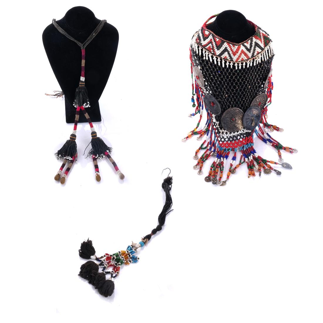 Central Asian Beaded Yoke Plus Belts: Central Asian beaded yoke with silver medallions, with belt or tassel decoration (3). [Yoke: 12 1/2 x 14 1/2 inches; Belt (piece separated from belt): 26 inches long].