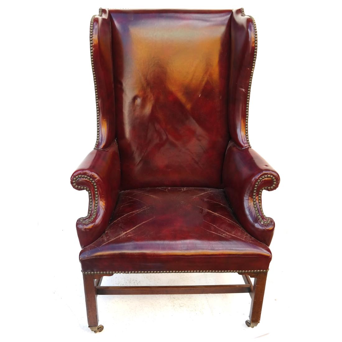 Antique english Red Leather Wing Chair: Antique English red leather wing chair, on casters. Leather worn.