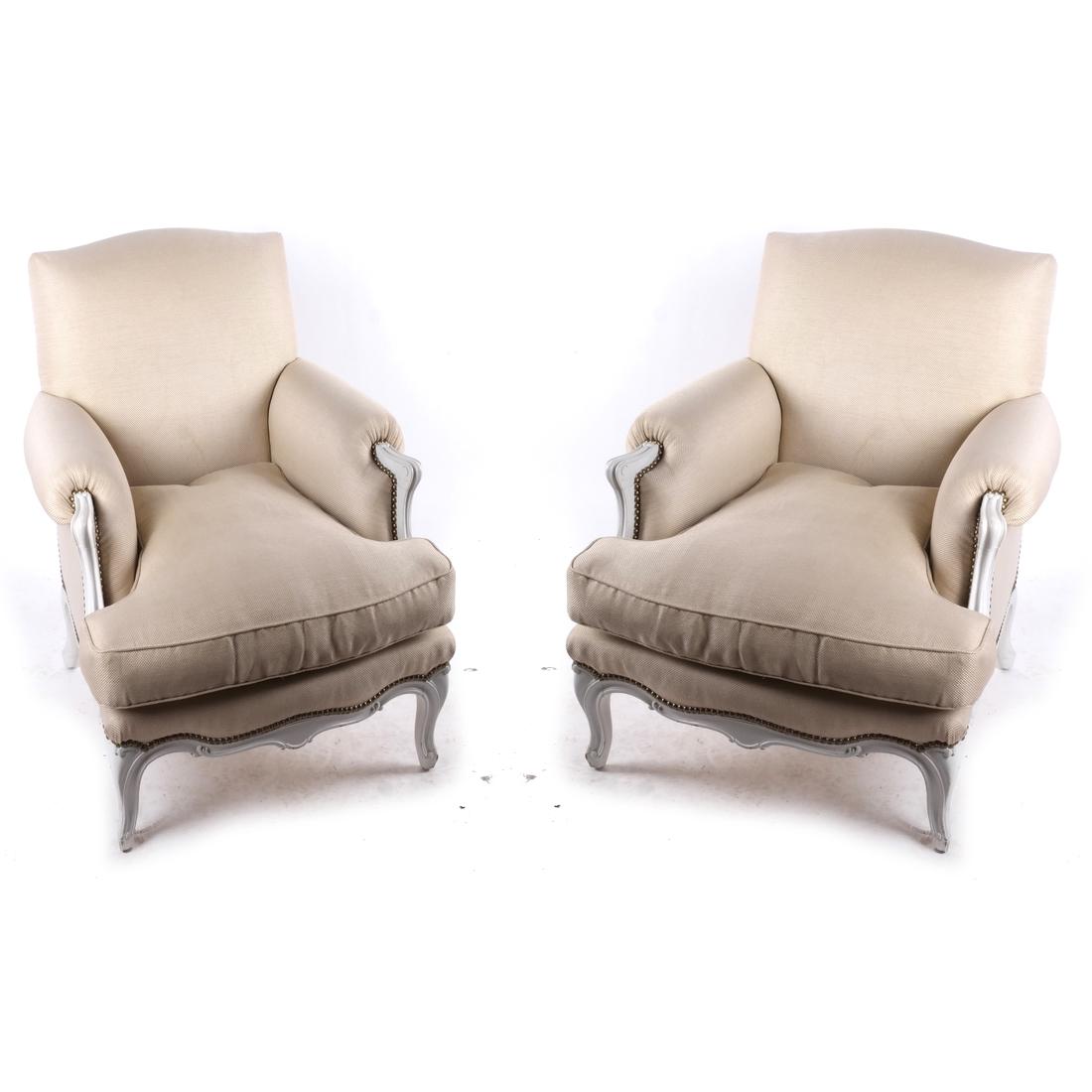 Pair of French Bergeres by Jensen: Pair of white painted bergeres with creme upholstery and nail head trim. [33 1/2 x 31 x 30 inches; 18 inches to seat]. Stains to upholstery.