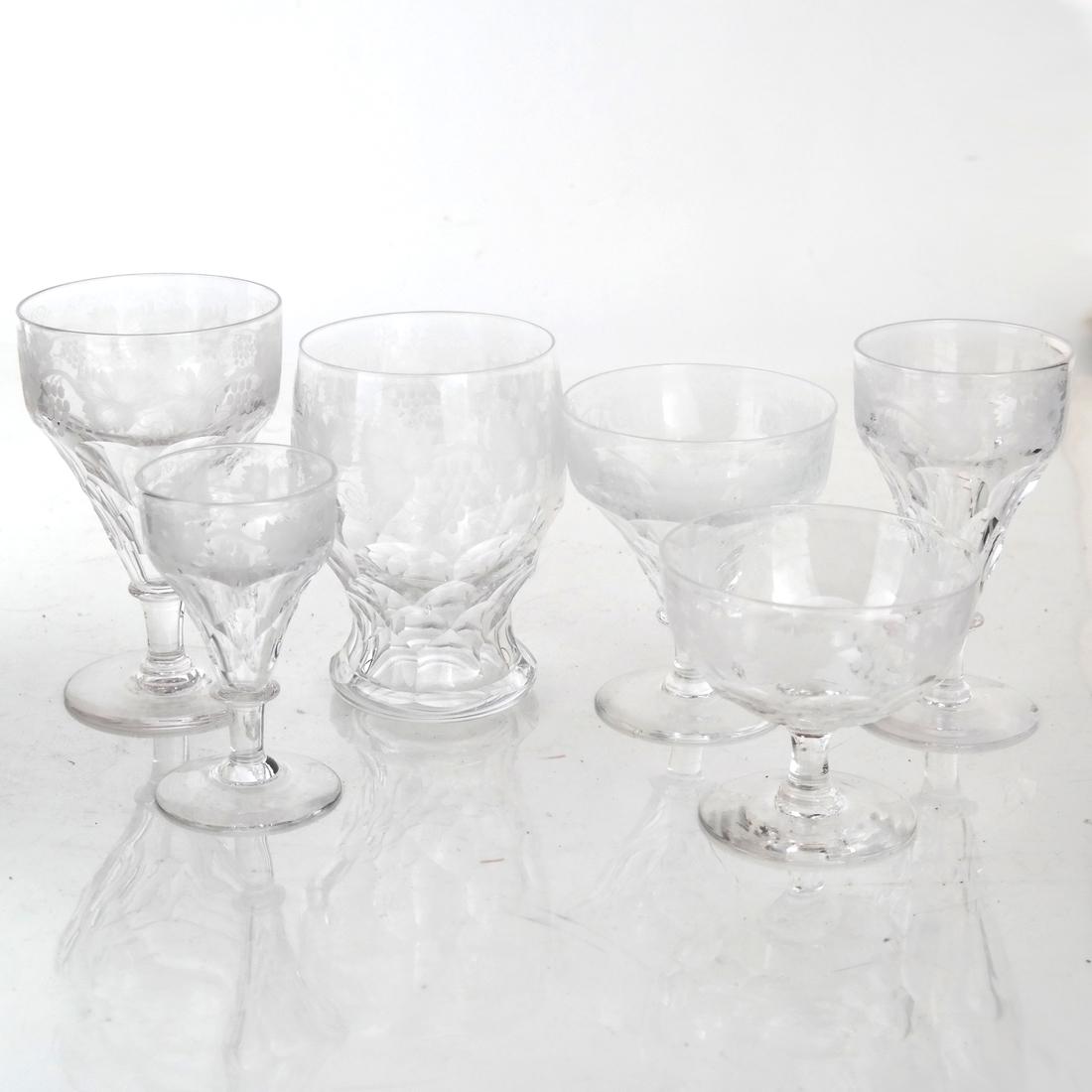 69 Pcs. Etched Crystal Stemware, Clear: Stemware service including 10 wine, 12 champagne, 8 sherry, 9 champagne, 10 rocks, 12 cordial, 8 others. Most in overall good condition. Some with minor chips to rims.