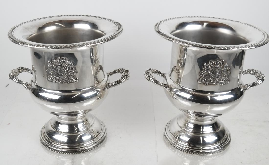 Pair of Silver Plate Wine Coolers: Pair of matching trophy-form wine coolers/ice buckets, with gadrooned molded bases and rims, applied reeded handles and a coat of arms. [10 x 9 (dia) inches]. In good condition.