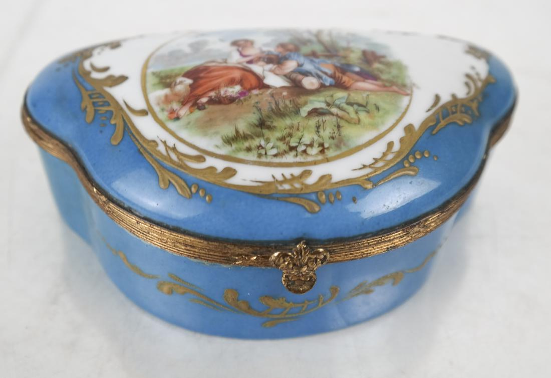 French Sevres-Style Trinket Box: Sevres-style porcelain dresser box, 20th century, of shaped scallop form with a domed lid and gilt bronze mounts, having a painted reserve of lovers in a country setting on the lid, the interior and s