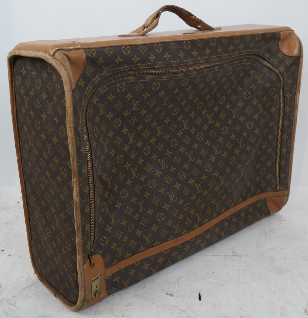 Louis Vuitton Suitcase: Louis Vuitton Saks Fifth Avenue suitcase in brown and tan monogram coated canvas, with brass hardware, tan Vachetta leather trim, single flat handle at top, zip around closure at front opening to tona