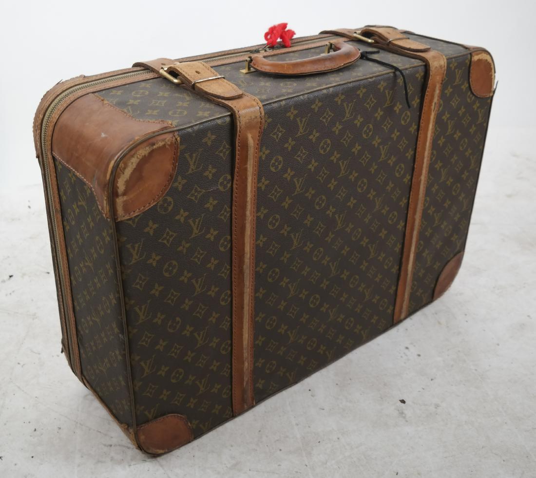 Louis Vuitton Suitcase: Louis Vuitton suitcase with monogram print and leather straps. 18 x 26 x 9 inches]. Leather patination, wear, scuffs.