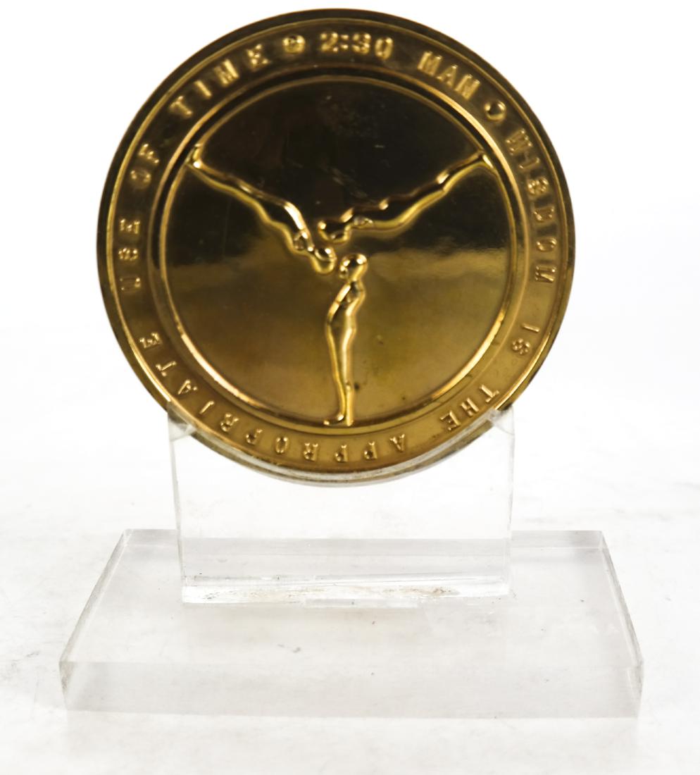 Ernest TROVA: Medallion on Lucite Stand, "Manscape: Ernest Trova, medallion on lucite stand, "Manscape". [Medal: 1/4 x 4 (dia) inches; Stand: 5 x 2 1/2 inches]. Medal in good condition; lucite stand needs re-gluing.