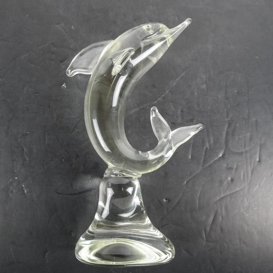 Crystal Dolphin Sculpture: Crystal sculpture of a leaping dolphin. [11 1/2 x 61/2 x3 1/4 inches]. One flipper missing.