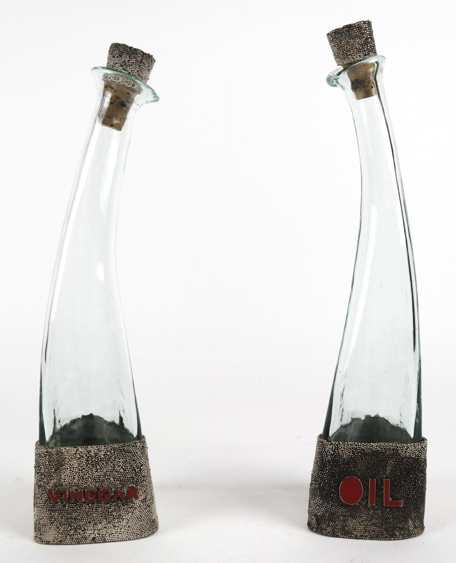 Art Deco-Stylize Oil & Vinegar Bottles: Pair of mid-20th century Art Deco-stylize, glass oil and vinegar bottles. Chip at rim of one bottle.