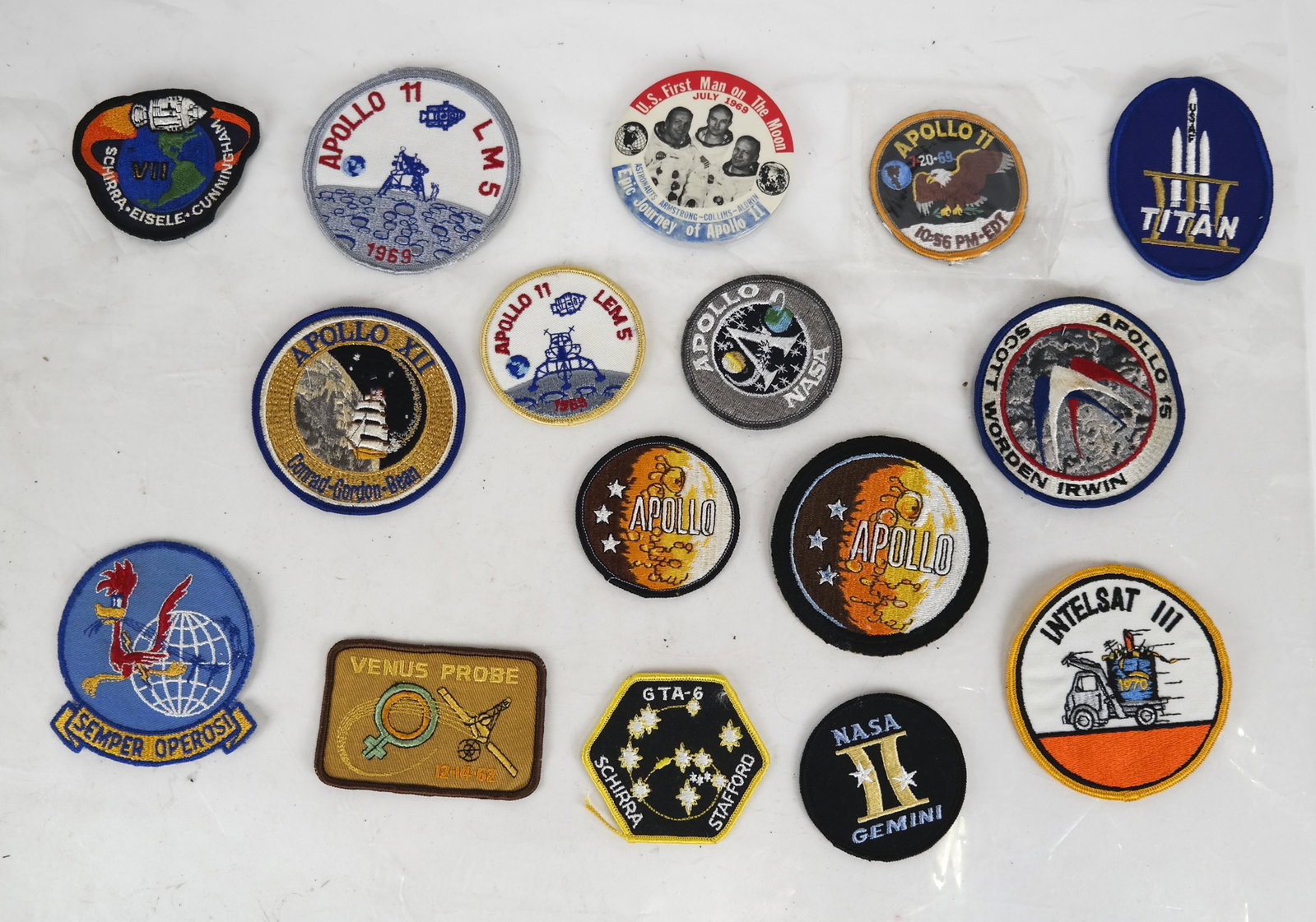 First Man on the Moon Button, 14 Patches: Epic Journey of Apollo 11 button, together with Apollo 11 patches, five other Apollo mission patches, Venus, Titan and four others. Fifteen pieces total.