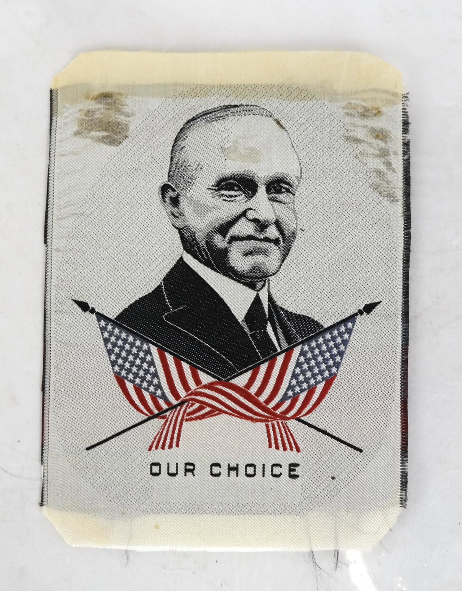Unlisted Calvin Coolidge "Our Choice" Silk Ribbon: Measures 5 3/4 x 4 inches, featuring bust image of Calvin Coolidge with pair of 48-star crossed American flags, red, white, blue, black. Note tape stains top right and left corners, small foxing on fo