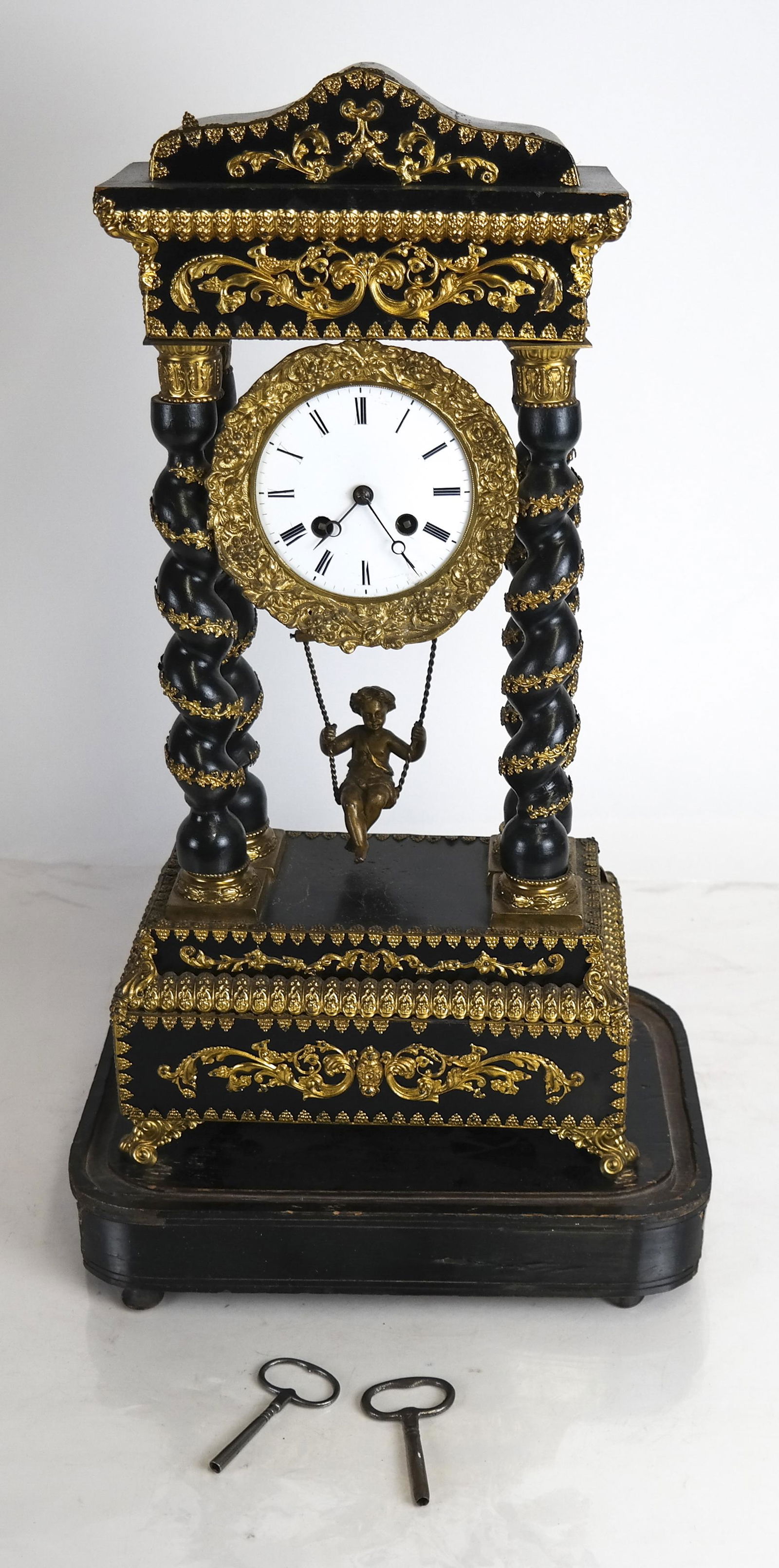 19th Century Napoleon III Gilt, Ebony Clock: 19th century Napoleon III gilt and ebony clock with a figure on a swing as a pendulum. [Clock only: 20 x 9 1/2 x 6 inches].