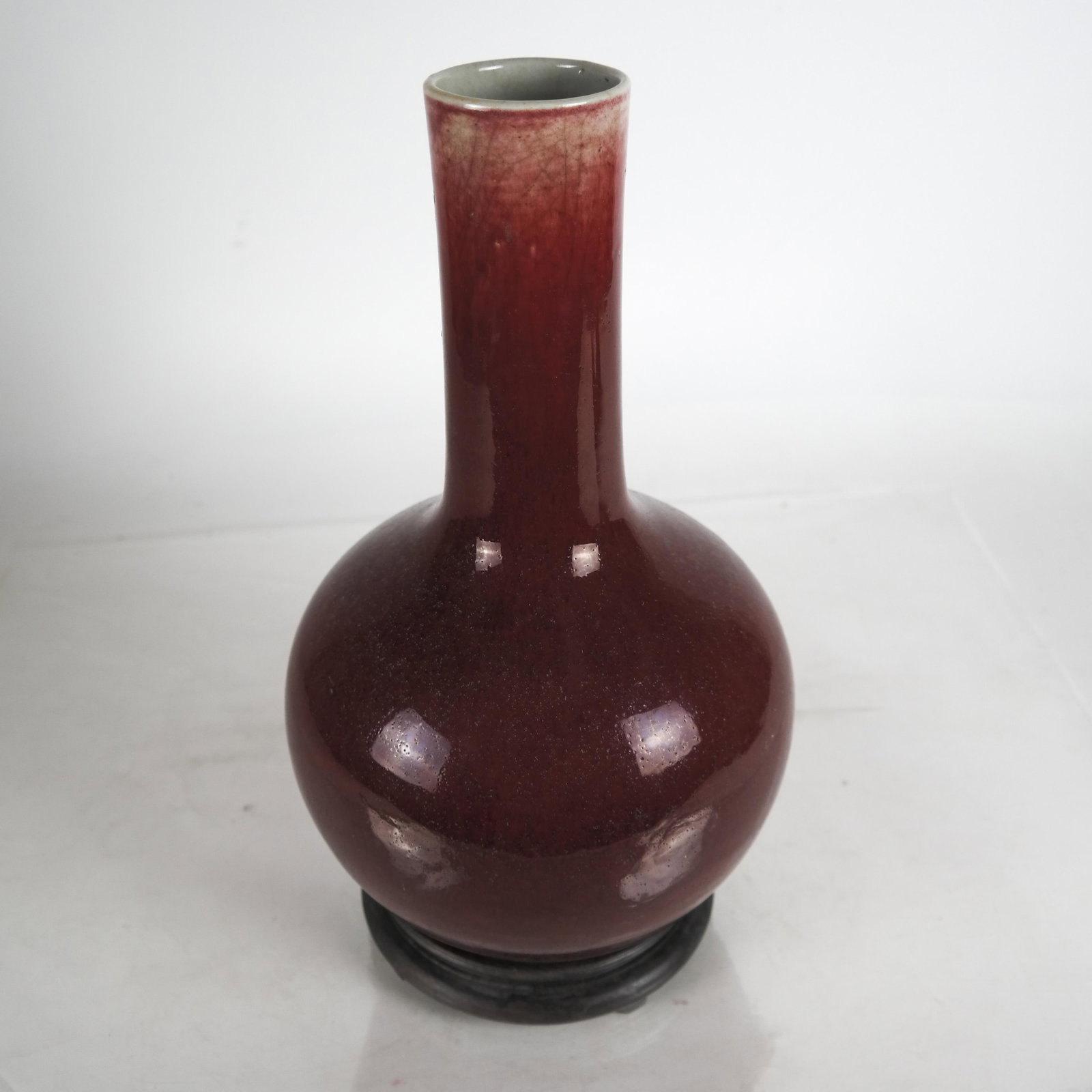 Chinese Antique Sang De Boeuf Vase: Chinese antique sang de boeuf vase on a wood base. [14 inches high, without base]. In good condition.