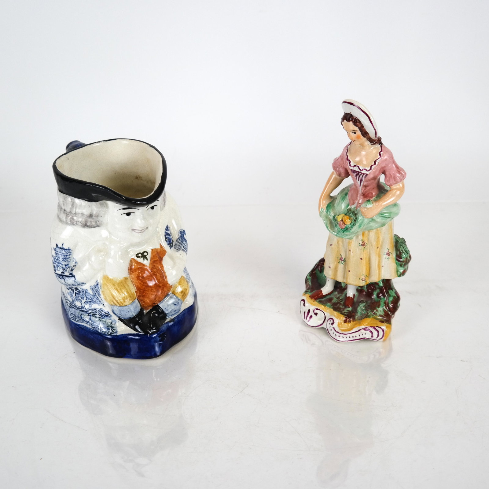 Toby Jug and Figurine of Lady: Porcelain Toby Jug with Blue Willow pattern on one side [5 3/4 inches high], and an English porcelain figurine of a woman [7 1/2 inches high].