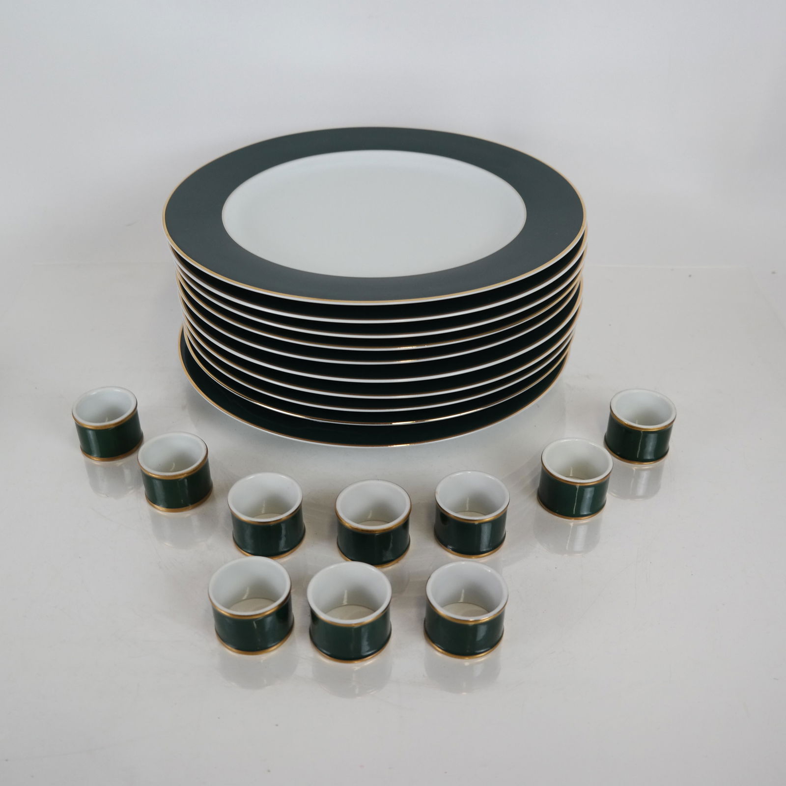 Christofle Plates and Napkin Rings: Set of 10 plates, white with teal border, together with 10 Fitz & Floyd napkin rings. [11 1/2 (dia) inches].