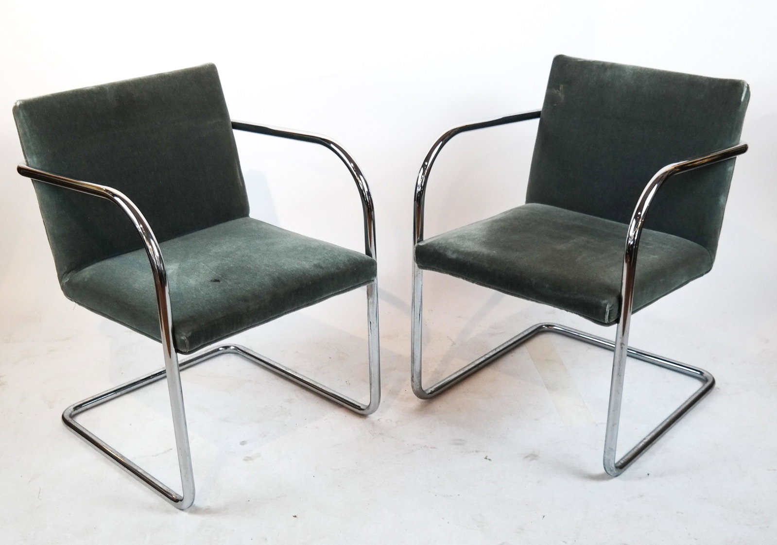 Pair of Mies Van Der Rohe "BRNO" Chairs: Pair of Mies van der Rohe for Knoll mid-century modern "Brno" arm chairs, cantilevered flat bar polished stainless steel frame, with grey velvet upholstery. [32 x 23 x 23 inches]. Spot of damage to up