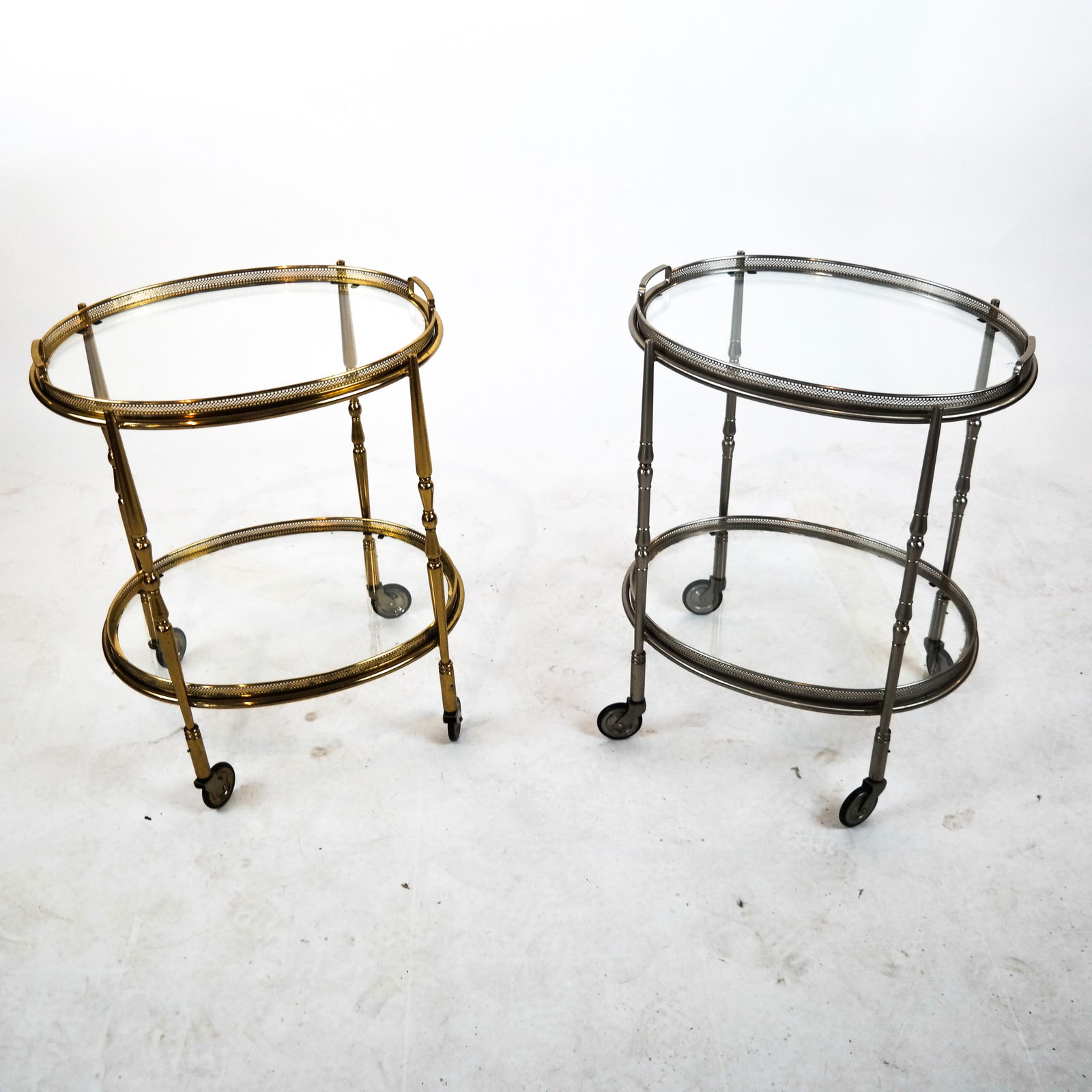 Pair of Two-Tone Tea Carts: Pair of two-tier rolling carts, one silver patina, one gold patina. All tiers removable (lift out). [23 x 17 x 14 inches]. All four glasses have chips.
