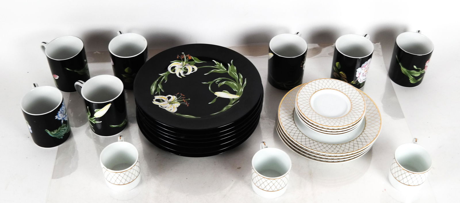 Two Tiffany & Co. Partial Dinnerware Sets: Eleven pieces of gold and white Tiffany & Co porcelain dinnerware and "Mrs. Delany's Flowers" by Sybil Connolly for Tiffany & Co. dinnerware, including seven cups and eight salad plates, totaling 25 p