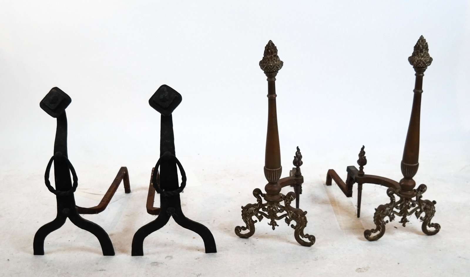Two Pairs of Antique Andirons: Two pairs of andirons: 1) flame finial-form, and 2) Arts & Crafts-style. [26 x 10 x 20 inches; 20 1/2 x 10 x 20 inches].