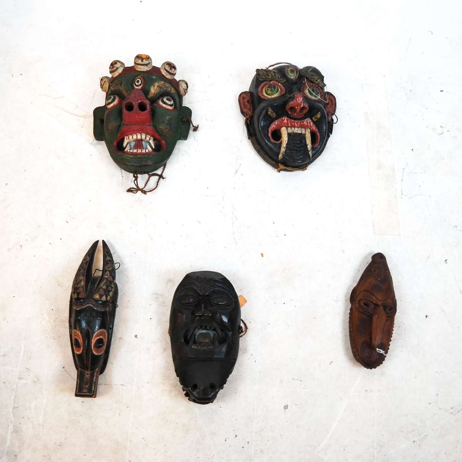Five Tribal Wood Masks: Five tribal wood masks. [11 1/2 x 11 inches; Largest: 12 1/2 x 11 inches]. In overall good condition.