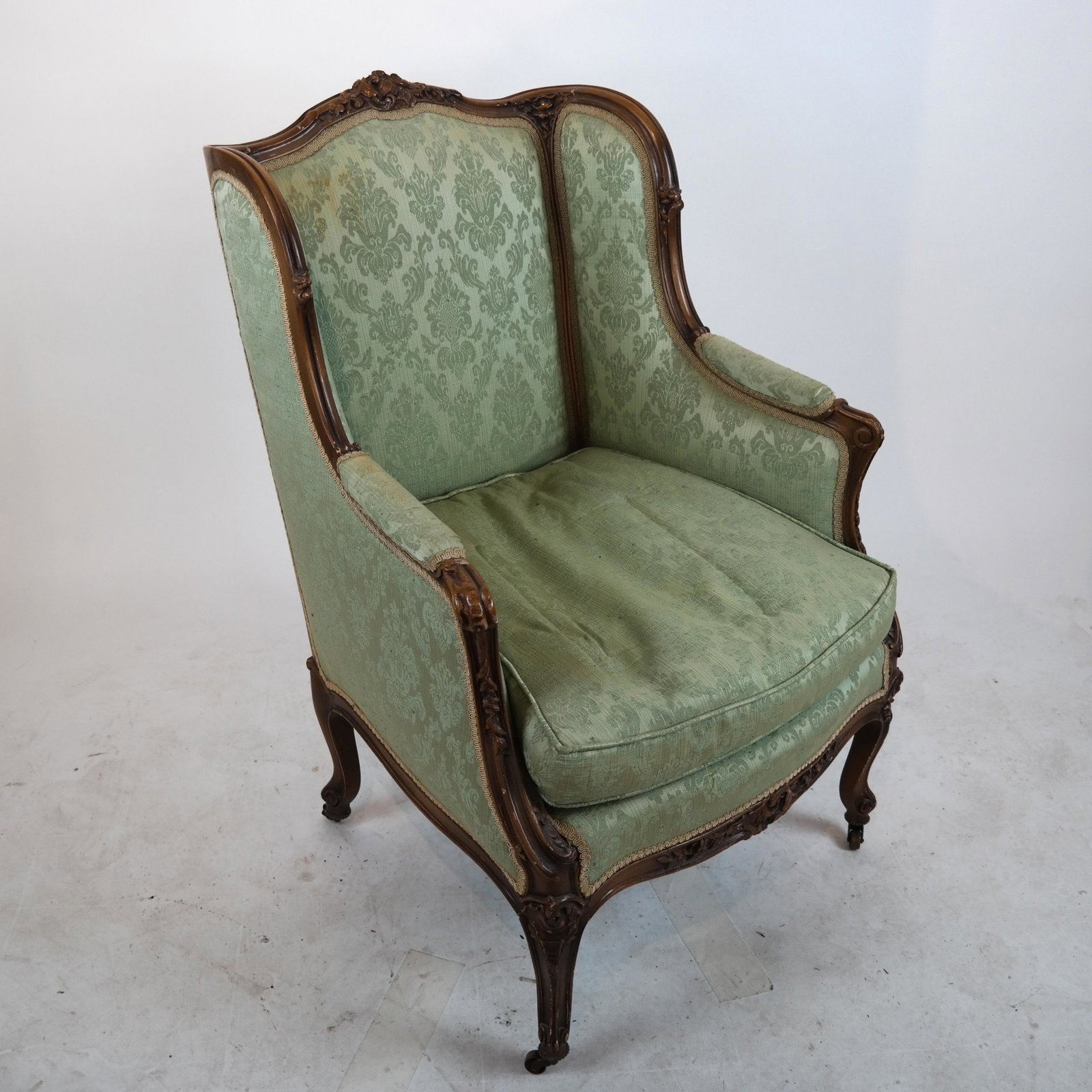 Antique French Carved Bergere: Louis XV-style carved bergere, with green (worn) upholstery.