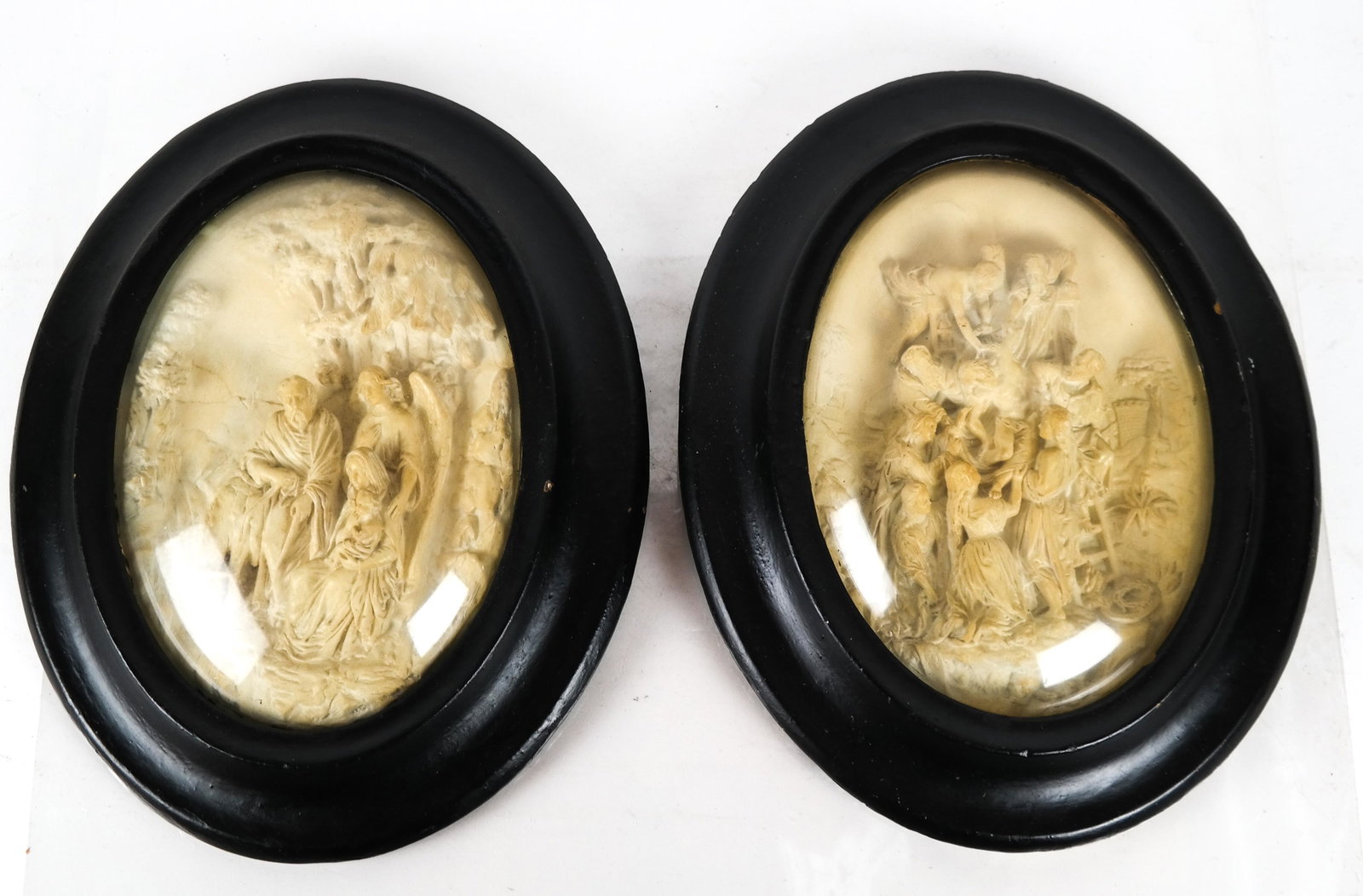 Pair of Limestone-Style Reliefs: Pair of oval figural reliefs, one depicting the Holy Family, the other the Crucifixion of Christ. [16 x 13 inches]. One split.