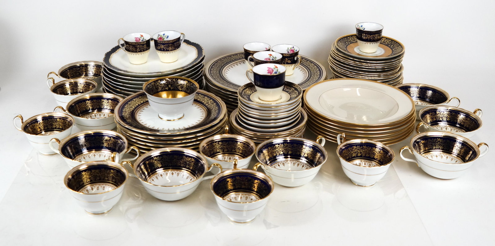 Aynsley & Lenox Bone China Dinnerware: Assembled lot of Aynsley, England porcelain dinnerware, in three patterns, having cobalt and gilt borders, 84 pieces; plus 7 Lenox soup bowls. In good condition.