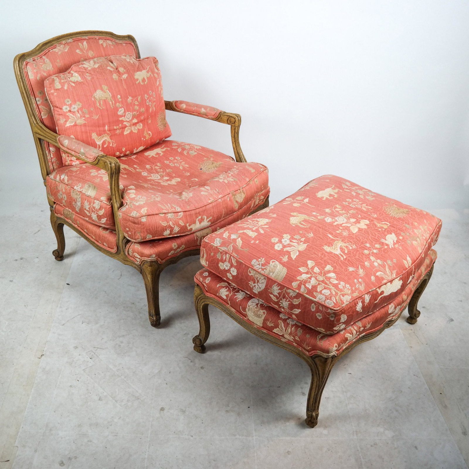 Louis XV-Style Fauteuil and Footstool: 20th century Louis XV-style painted fauteuil arm chair with footstool. [Chair: 34 x 32 x 24 inches]. Wear to upholstery and cushions.