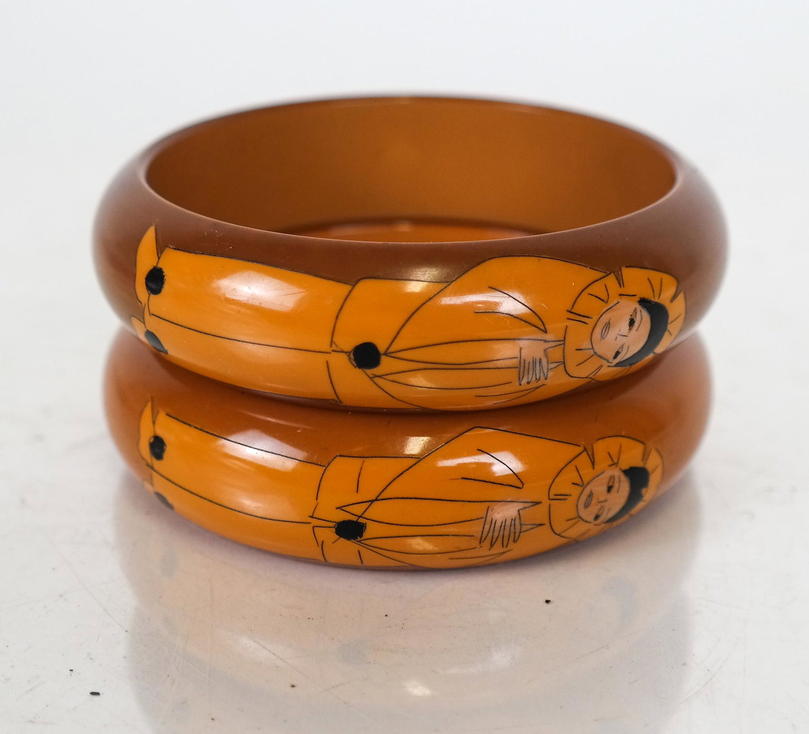 Pair Vintage Butler & Wilson Pierrot Bangles: Pair of Butler & Wilson vintage Galalith Pierrot bangles, in butterscotch bakelite, signed. In good condition.