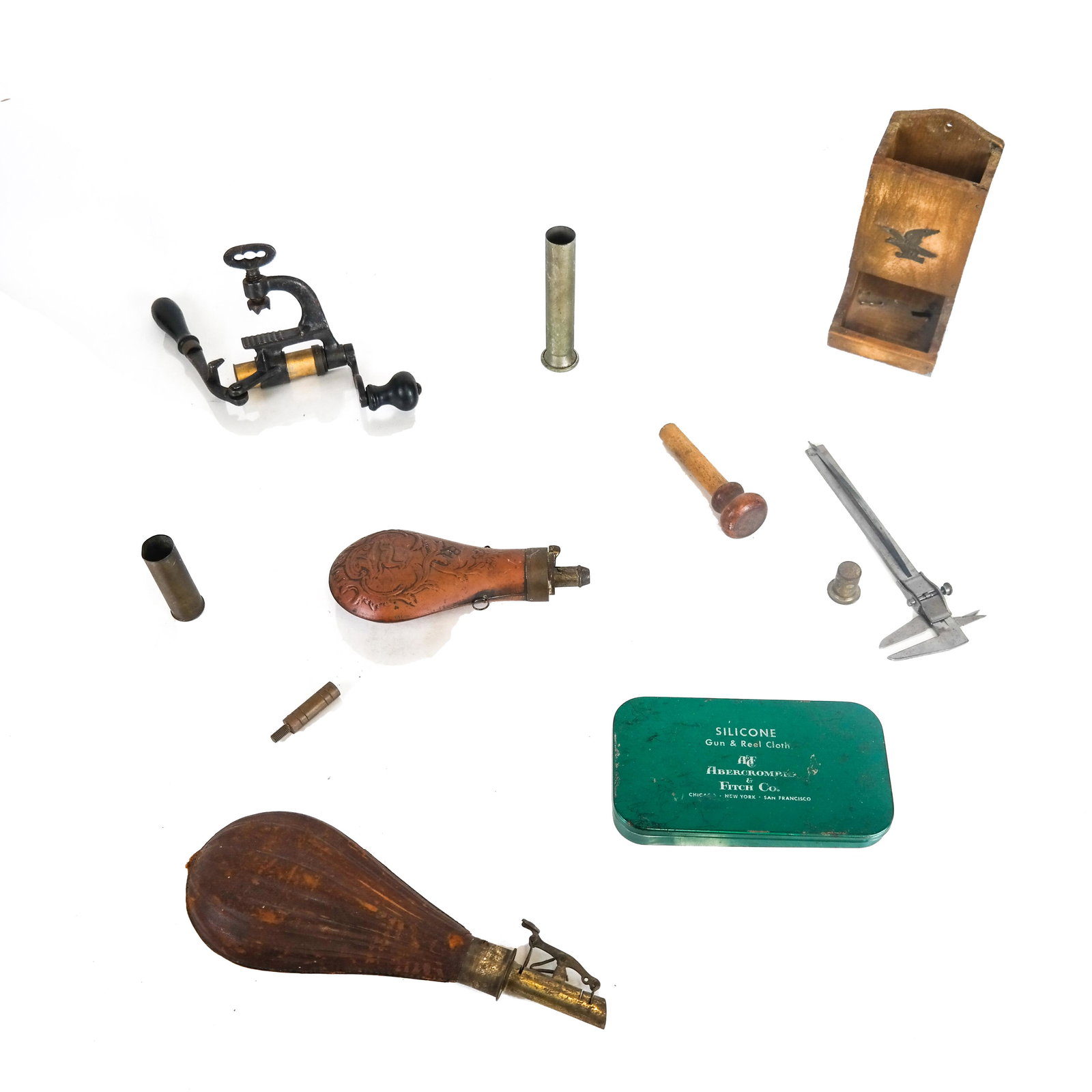 Two Gun Powder Flasks, and Other Items: Two gun powder flasks [Larger: 9 1/2"], together with a tin gun cloth box and a few miscellaneous items. Provenance: Wildfowler Decoys, Inc. (Quogue) and Peacock Point, Long Island estate.