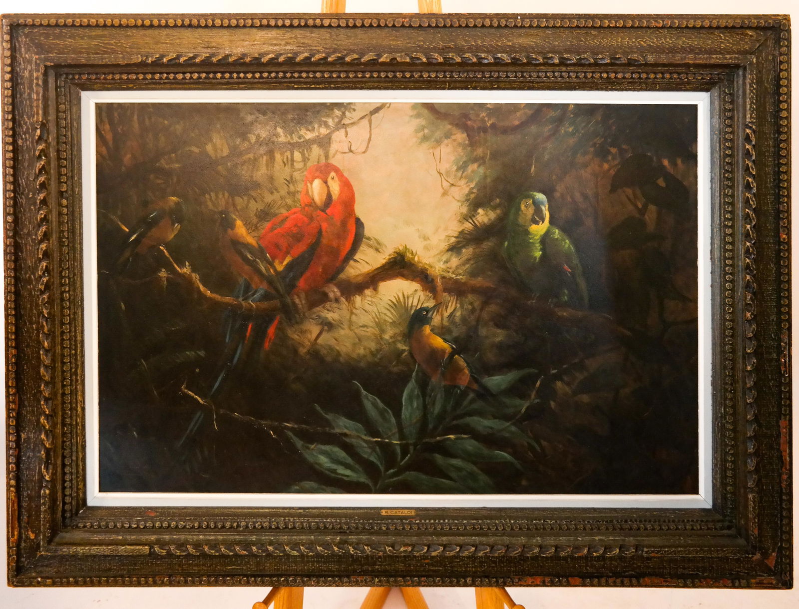 Three Parrots - Oil on Masonite: Oil on masonite painting of three parrots in foliage, in an ornate frame. [Art: 26 x 39 1/2 inches; Frame: 38 x 50 1/2 inches]. Art in good condition; frame with losses.