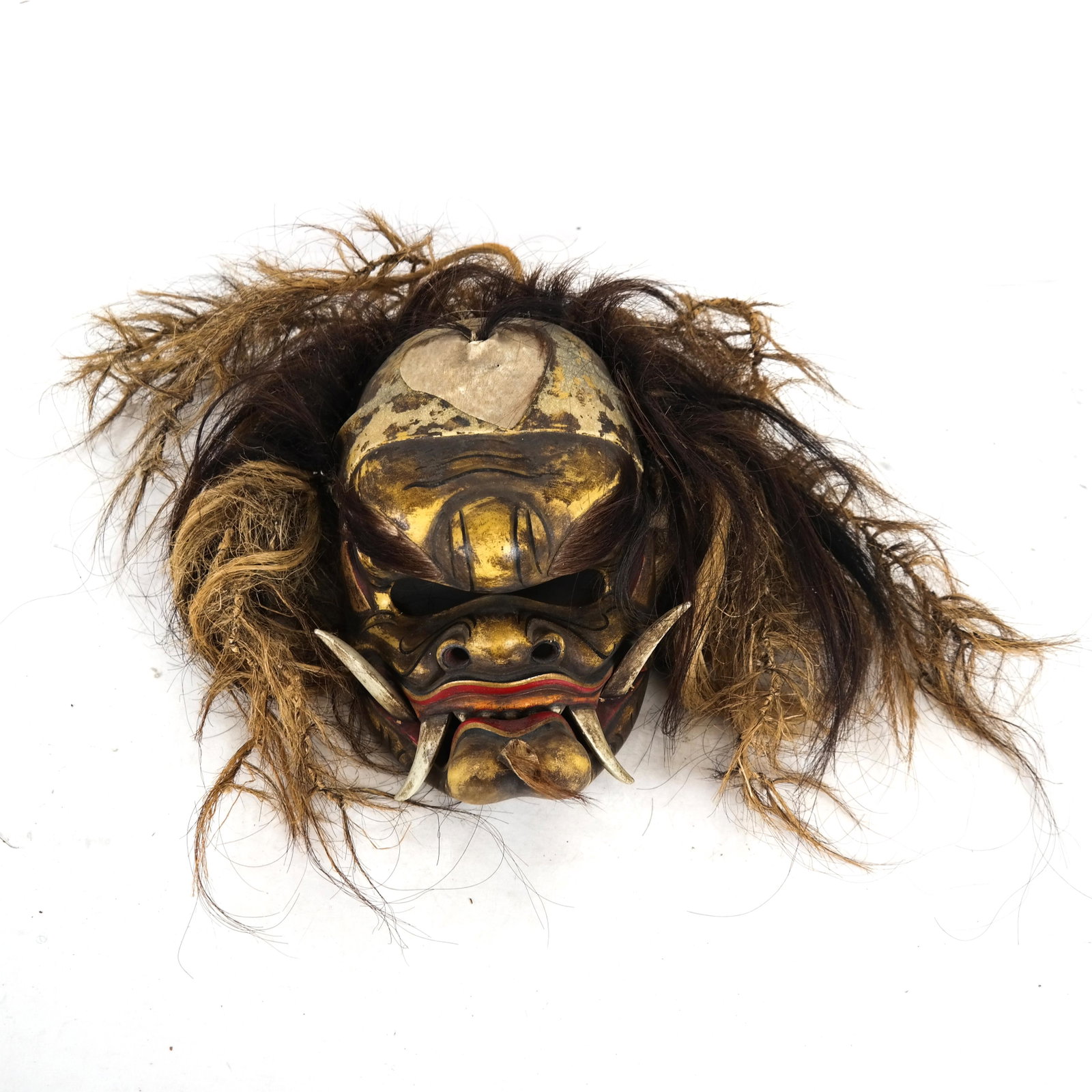 Vintage Balinese Carved Wood Mask: Vintage Balinese mask with hinged, articulated lower jaw and woven fiber hair. [10 3/4 x 6 x 6 inches (without the hair]. In good condition, with wear as with age.