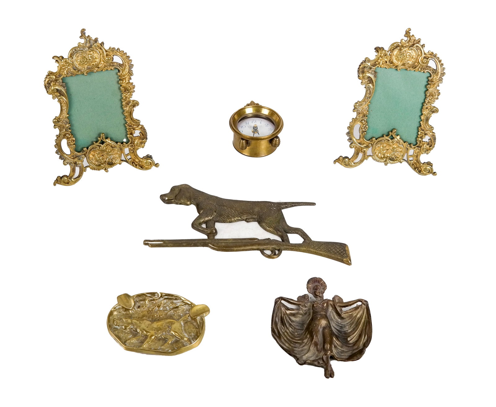 Six Mixed Metal Objects: 1) A pair of bronze dore table picture frames, 2) A dog and rifle wall hanging, 3) A figural female tray, 4) Gilt dog ashtray, 5) Madame Giselle desk clock.