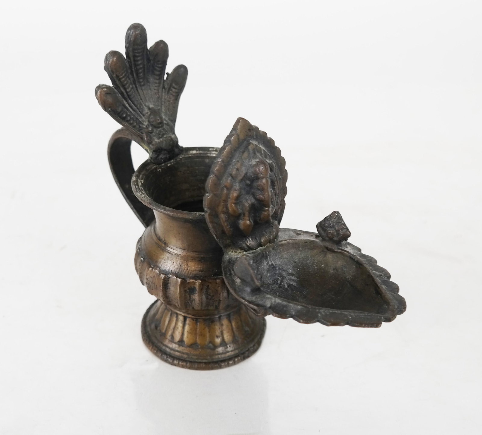 Bronze Hindu Devotional Lamp: Antique reservoir bronze oil lamp with depictions of Ganesh and other deities. [5 1/8" H x 2 1/4" W x 6" D].