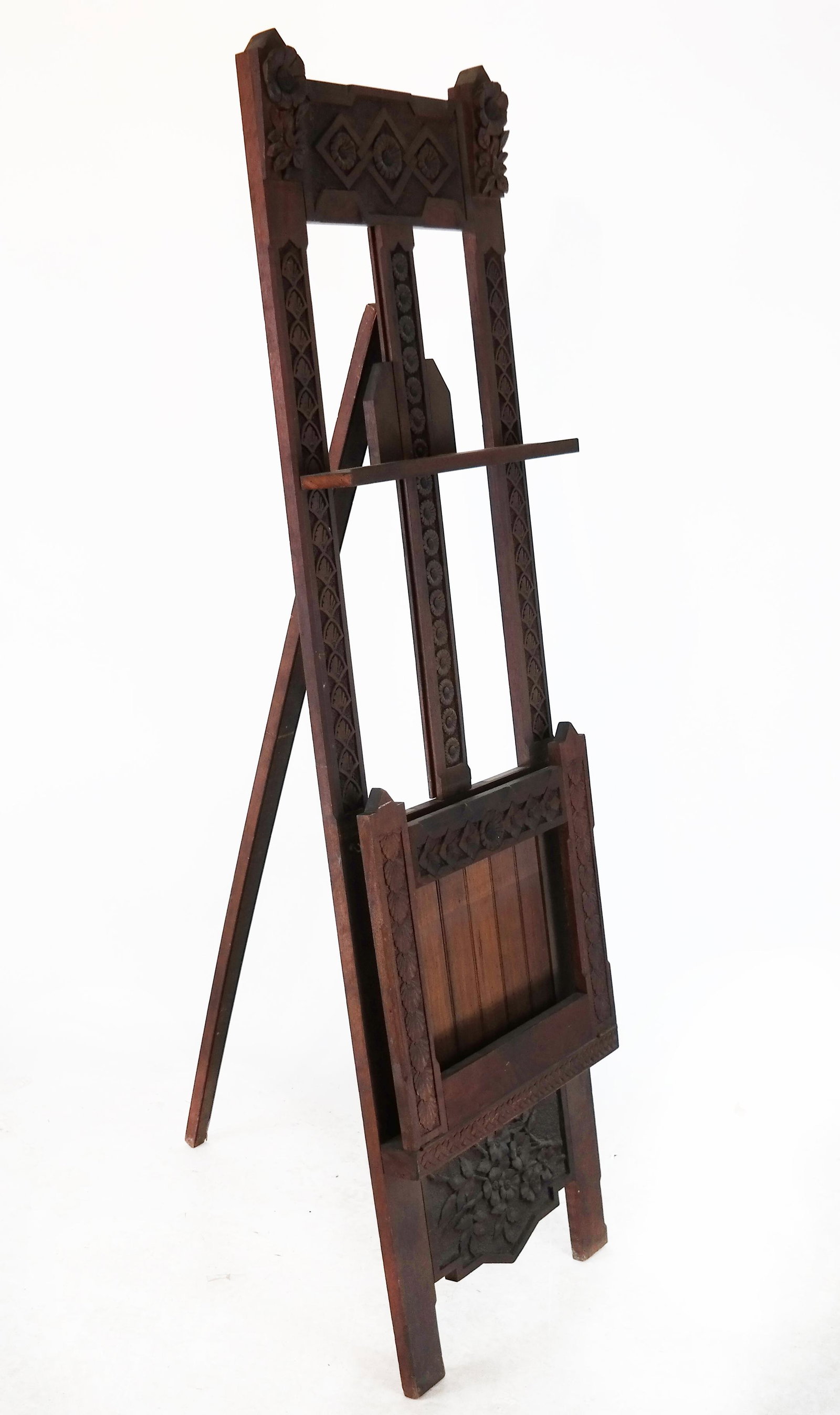 Arts & Crafts Carved Easel: Standing Arts & Crafts / Aesthetic Movement easel / art display stand, with carved floral bottom panel and rosette and fan carved decorations around the frame, having a hinged oak leaf and acorn carve